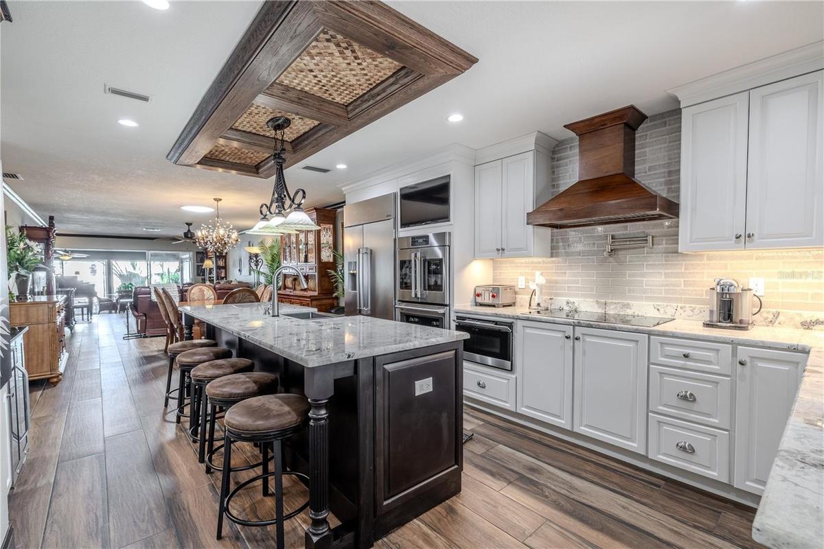 Step inside to an open floor plan where the living area flows seamlessly toward the water, featuring recessed lighting and warm tile flooring througho