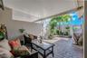 The front patio courtyard offers a peaceful outdoor retreat with brick pavers, a mounted fan, and direct access to both the garage and the second bedr
