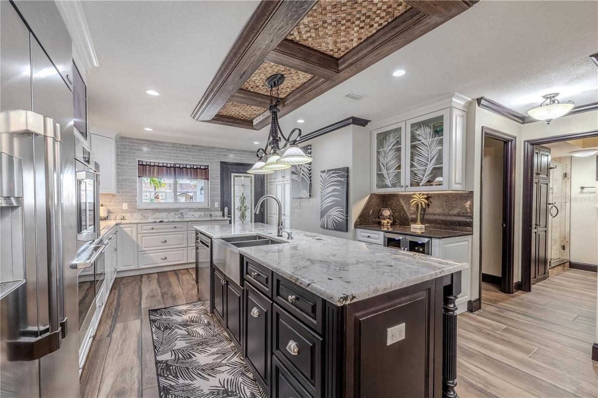 The open dining area creates a warm connection between the kitchen and living spaces, framed by water views and crown-molded ceilings.