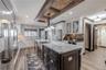 The open dining area creates a warm connection between the kitchen and living spaces, framed by water views and crown-molded ceilings.