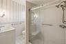 Glass-enclosed shower with a built-in bench and dual showerheads