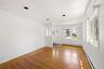 Living area featuring wood-finish flooring, white walls, and recessed lighting