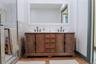 Bathroom featuring double vanity, wood finished floors, and an enclosed shower