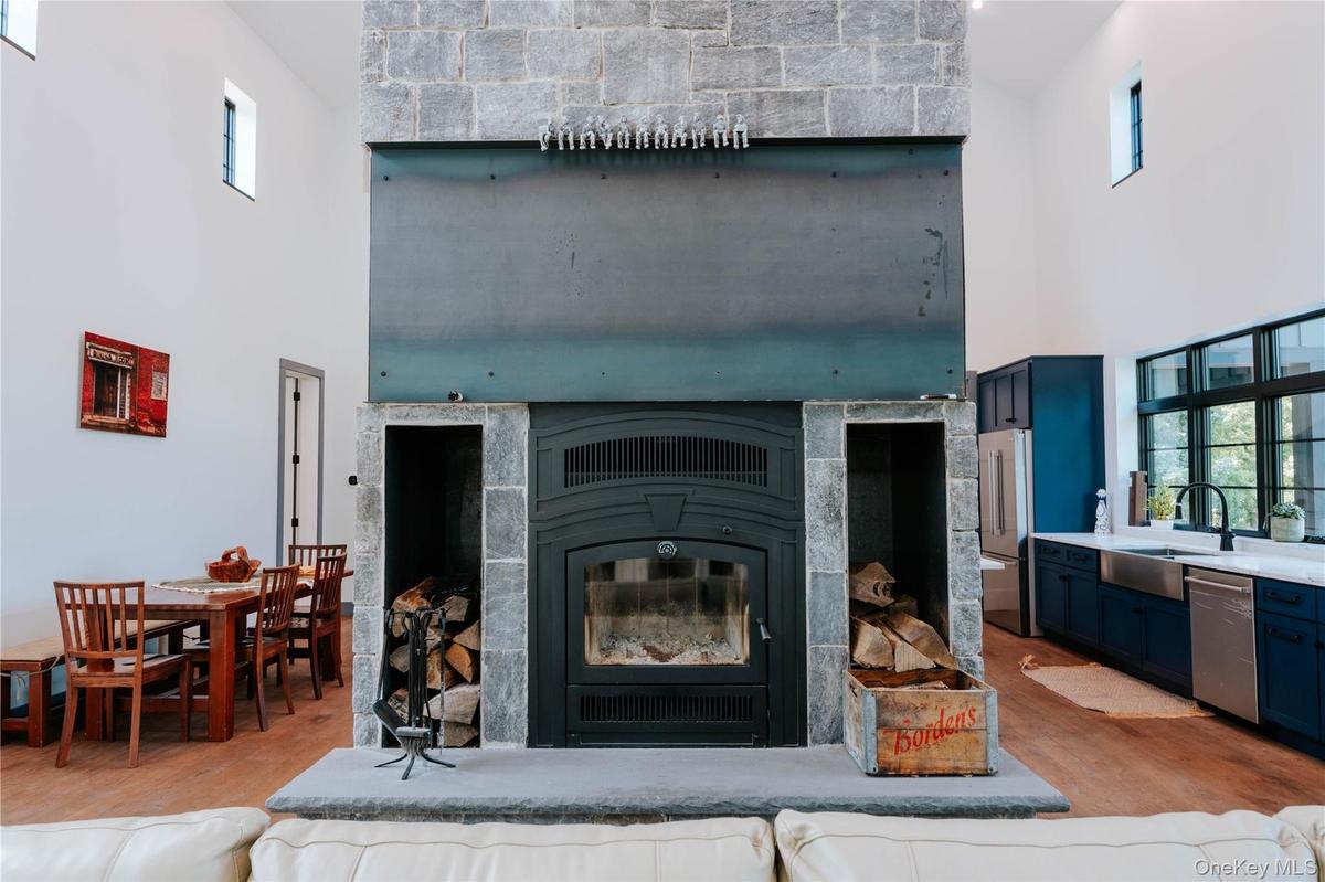 Detailed view of appliances with stainless steel finishes, wood finished floors, and a glass covered fireplace