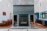 Detailed view of appliances with stainless steel finishes, wood finished floors, and a glass covered fireplace