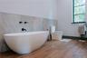 Full bathroom with wood finished floors and a freestanding tub