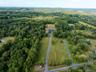 Aerial view of property and surrounding area with a forest