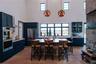 Kitchen with appliances with stainless steel finishes, light wood-style floors, light countertops, a kitchen breakfast bar, and blue cabinetry