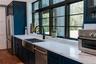 Kitchen featuring high quality fridge, light stone counters, dishwasher, and dark wood-style floors