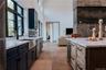 Kitchen with light stone counters, light wood finished floors, open floor plan, wine cooler, and tasteful backsplash