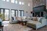 Living area featuring a high ceiling, a glass covered fireplace, and wood finished floors