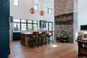Bar with light wood-style floors, a high ceiling, pendant lighting, stainless steel fridge, and a fireplace
