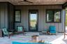 View of exterior entry featuring a patio, board and batten siding, and a ceiling fan