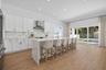 Generous kitchen with waterfall quartz countertop island.