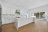 Generous kitchen with waterfall quartz countertop island.