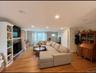 Spacious living area featuring wood-finish flooring, recessed lighting, and crown molding