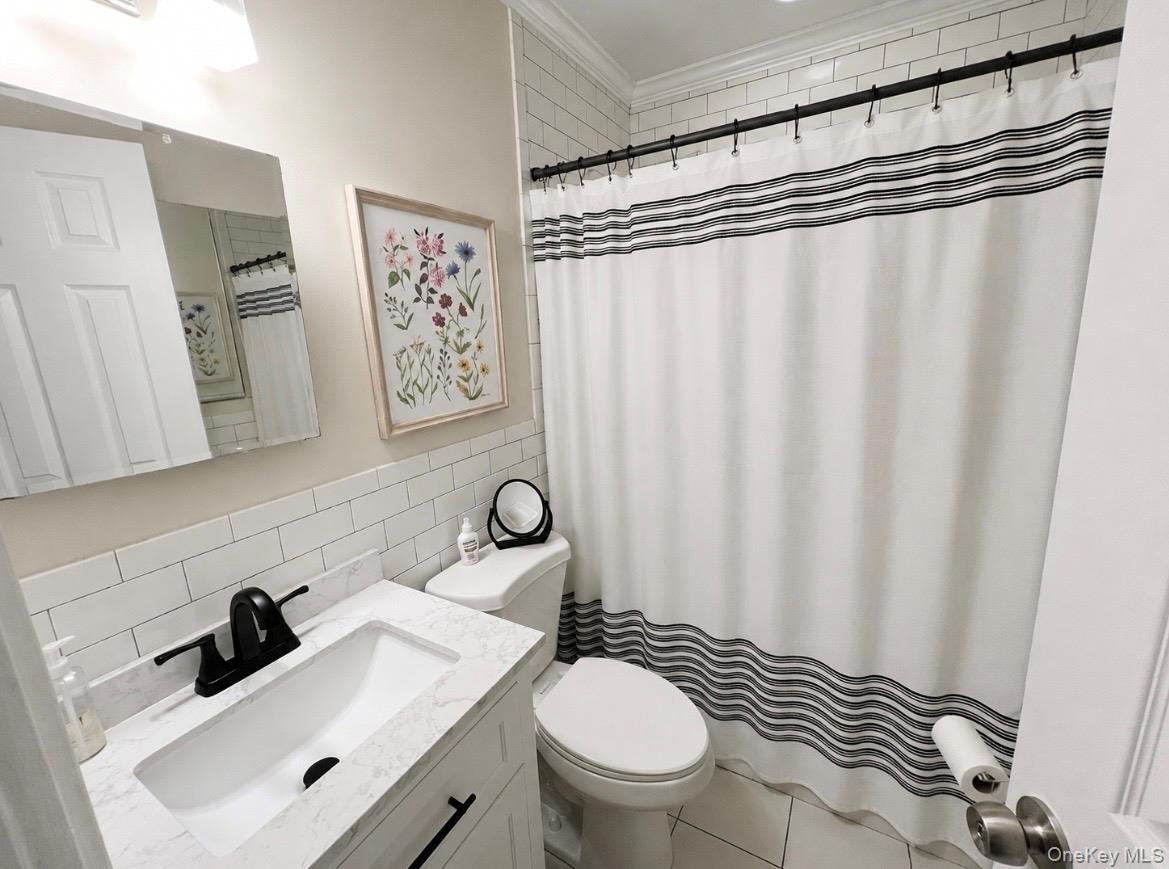 Bathroom featuring a modern vanity with integrated sink, quartz-finish countertop, and matte black faucet