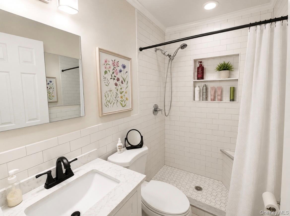 Bathroom featuring a shower with white subway tile surround and a built-in niche