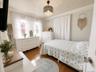 Hardwood flooring, natural light through multiple windows, beadboard ceiling, crown molding, and an ornate ceiling fixture