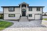 View of front of home with stucco siding, decorative driveway, and an attached garage