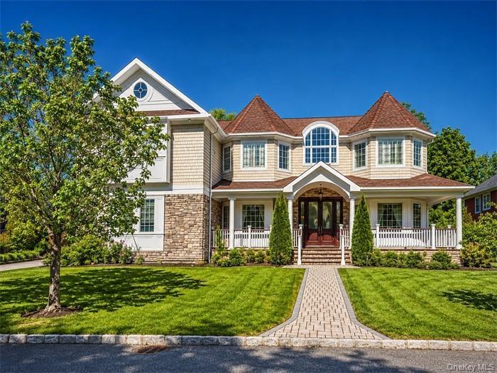 Shingle-sided residence featuring a stone-clad foundation and a covered front porch