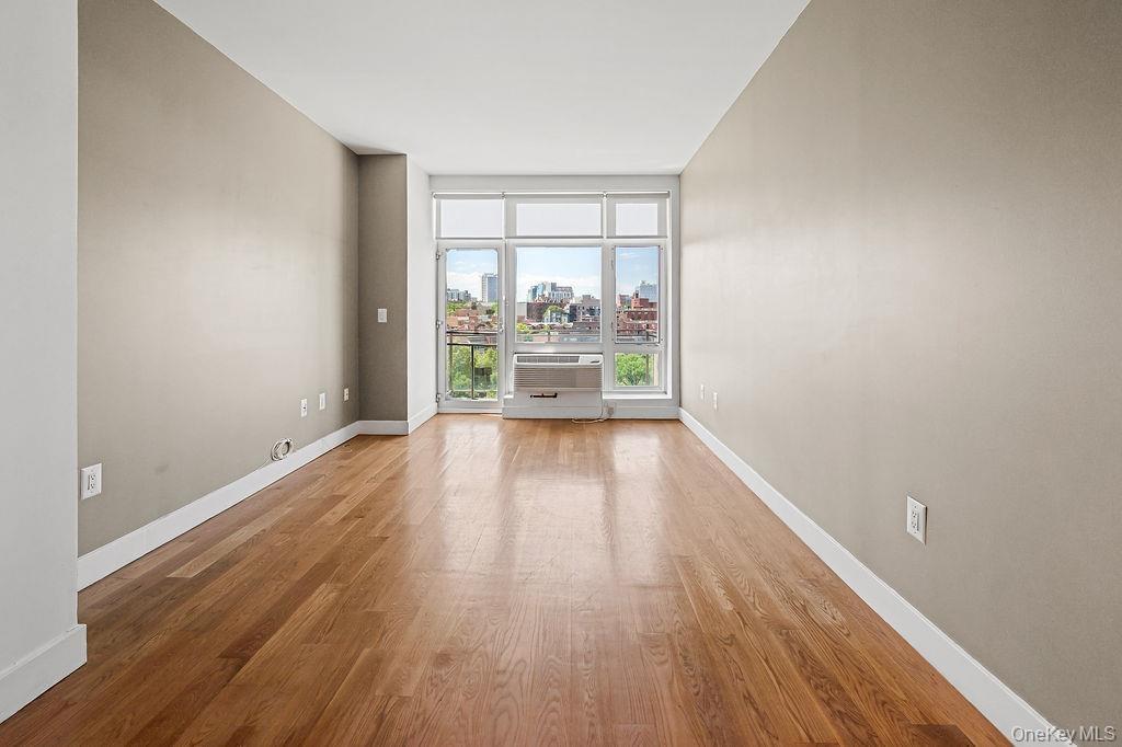 Hardwood flooring extending throughout, complemented by a large window with white framing