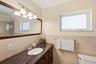 Primary En-Suite Bathoom with Custom Cabinet, Granite Countertop, Bathtub & Shower Combination with Glass Enclosure all behing a Frosted Glass Bathroo