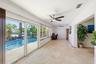 Your Florida Room has Front Seat to Your Specatular Waterfront Home with a Freeform Pool with Rock Waterfall, Dock, Covered Patio and Travertine Tile 