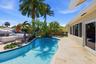 Beautiful Landscape Surrounds Your Waterfront Freeform Pool with Rock Waterfall adds to the Serene Waterfront Lifestyle.