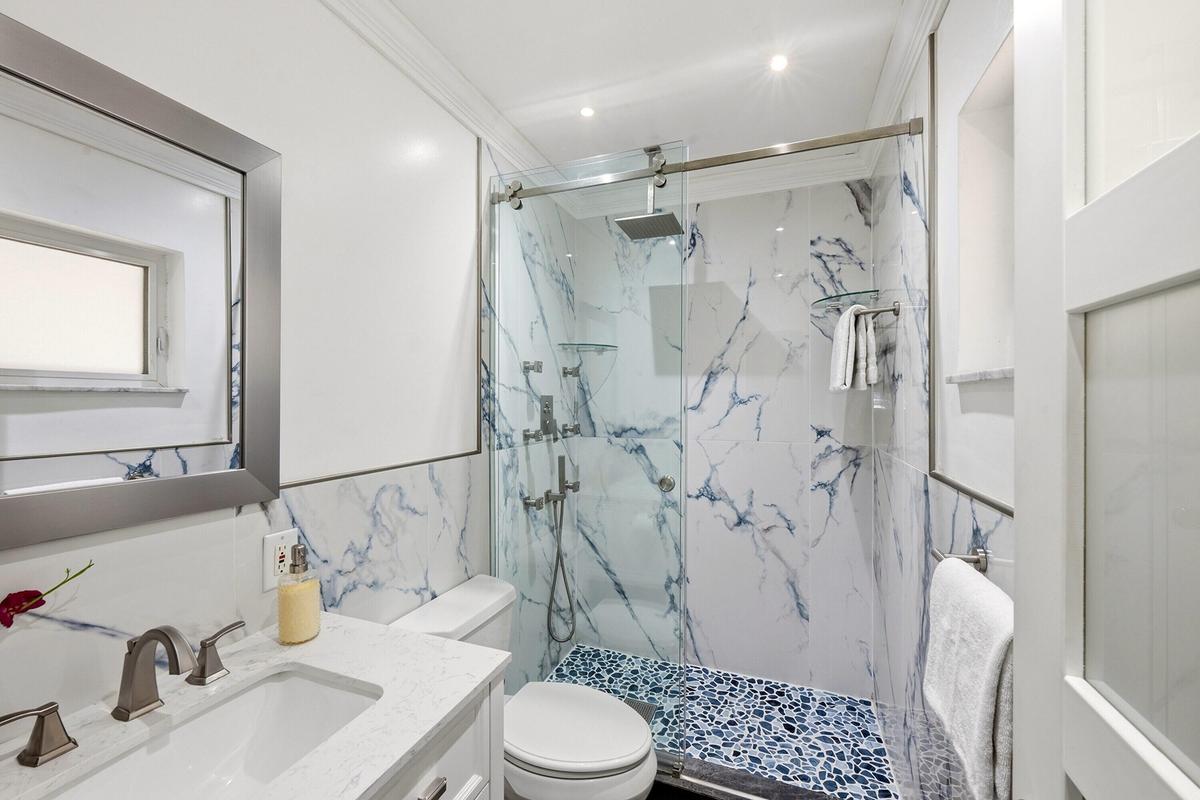 Guest Bathroom Updated 2025 with Glass Enclosed Shower and Frosted Glass Door and Window.