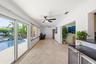Your Florida Room has Front Seat to Your Specatular Waterfront Home with a Freeform Pool with Rock Waterfall, Dock, Covered Patio and Travertine Tile 