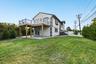 Back of property featuring stucco siding, a patio area, a lawn, and a deck