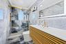 Bathroom with crown molding, tile walls, marble tiled flooring, a marble finish shower, and vanity