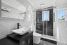 Bathroom with tile walls, vanity, a marble finish shower, and ornamental molding