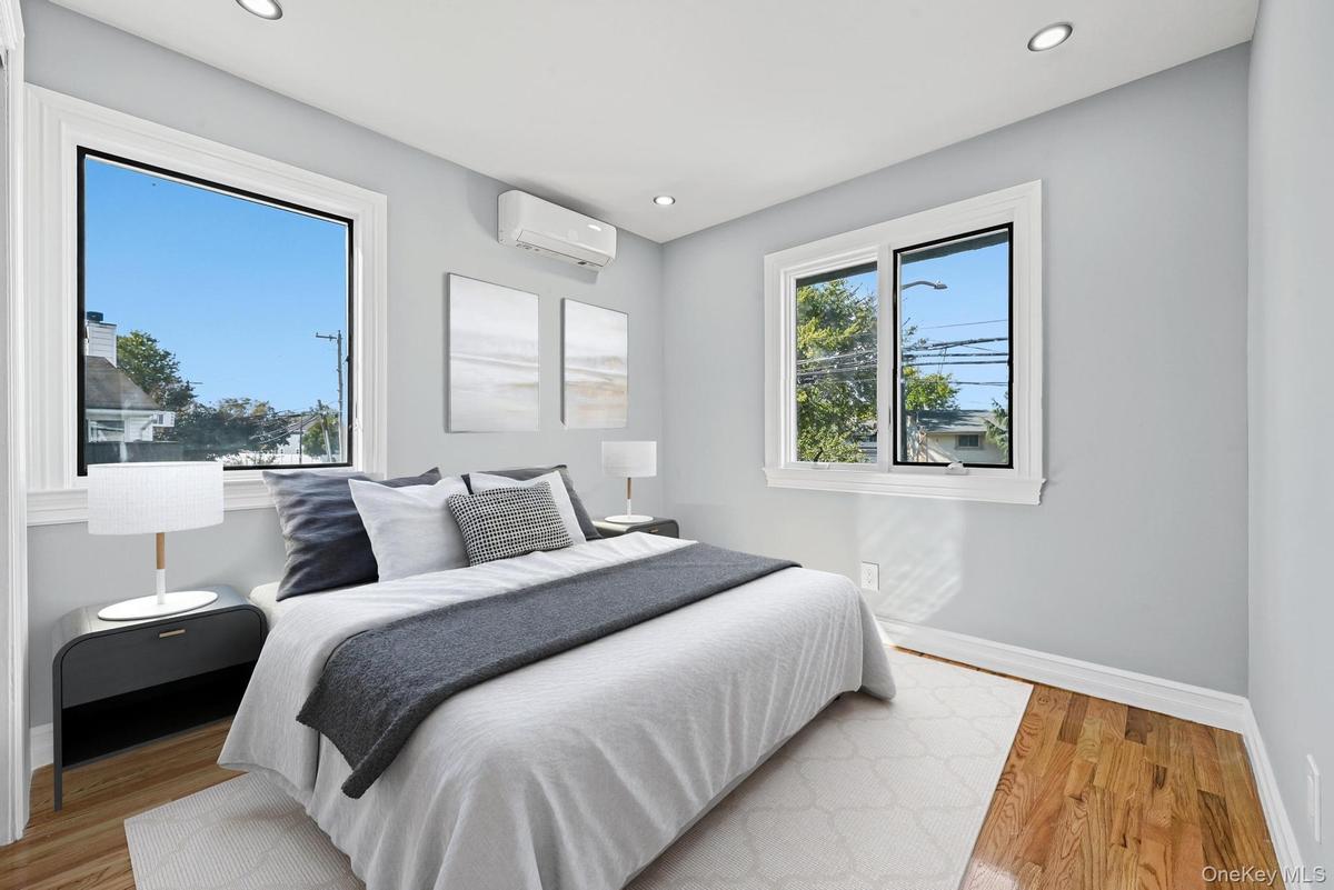 Bedroom with wood finished floors, recessed lighting, and a wall unit AC