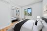 Bedroom with wood finished floors, a wall mounted air conditioner, recessed lighting, and a closet