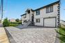 View of front facade featuring stucco siding, a garage, and decorative driveway