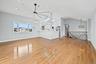 Unfurnished living room with light wood-type flooring, a skylight, vaulted ceiling, a ceiling fan, and recessed lighting