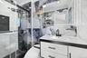 Bathroom with tile walls, a marble finish shower, and vanity