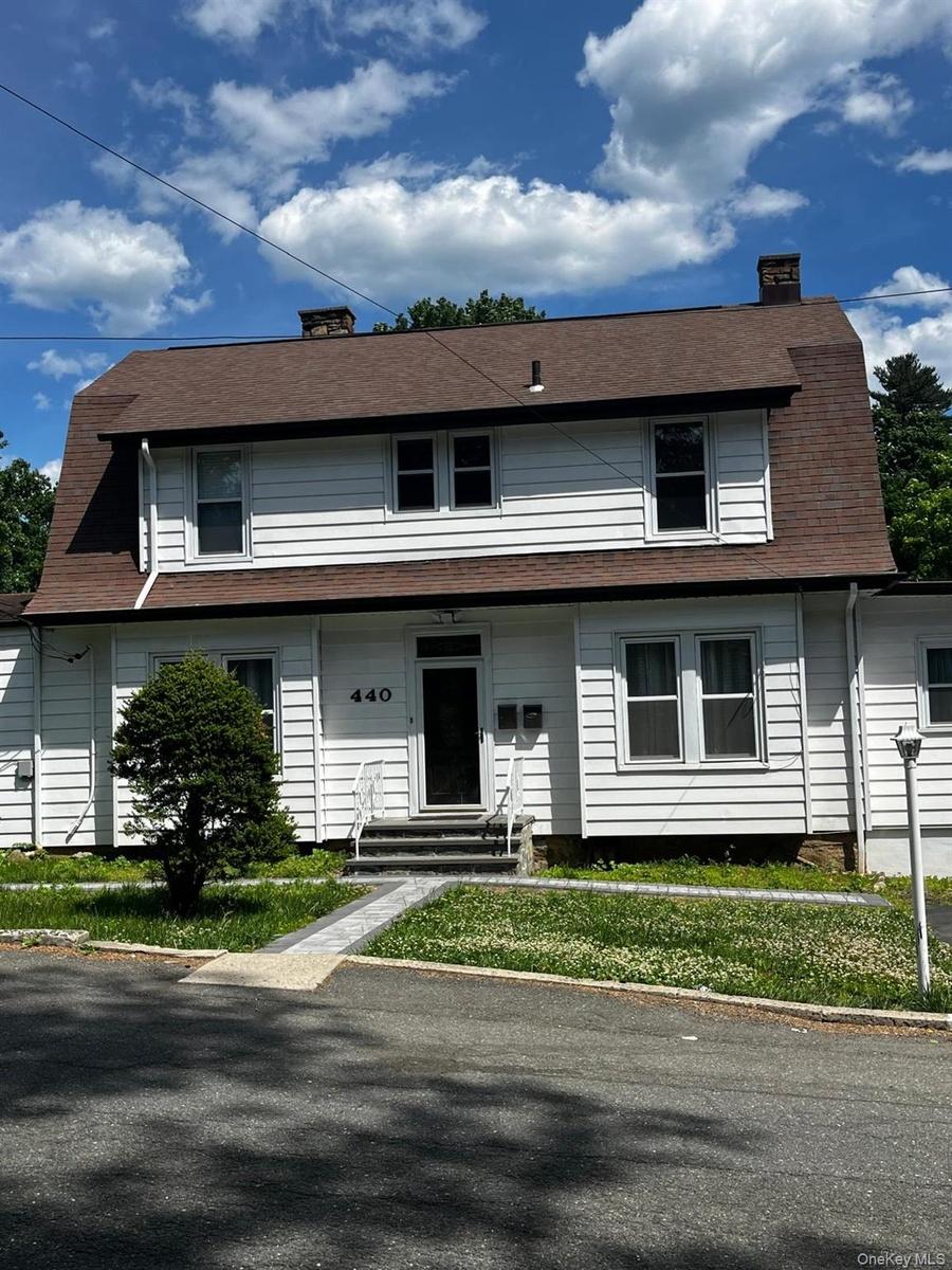 White clapboard siding exterior with a gambrel roof