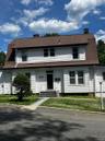 White clapboard siding exterior with a gambrel roof