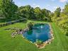 The largest of 3 koi ponds creates a park like feeling as you enter the property