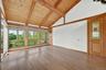 The primary suite is light and bright with walls of windows and a fabulous view of the pool deck, farm and beyond