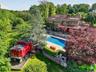 The expansive pool deck features a salt water pool, koi pond, hot tub, fire pit, outdoor cook area and a caboose!
