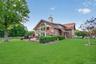 2nd home features a wall of windows to take in the views, a low deck for outdoor entertainment and an expansive lawn with koi pond