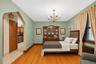 Hardwood flooring throughout, complemented by a brass chandelier and detailed window trim