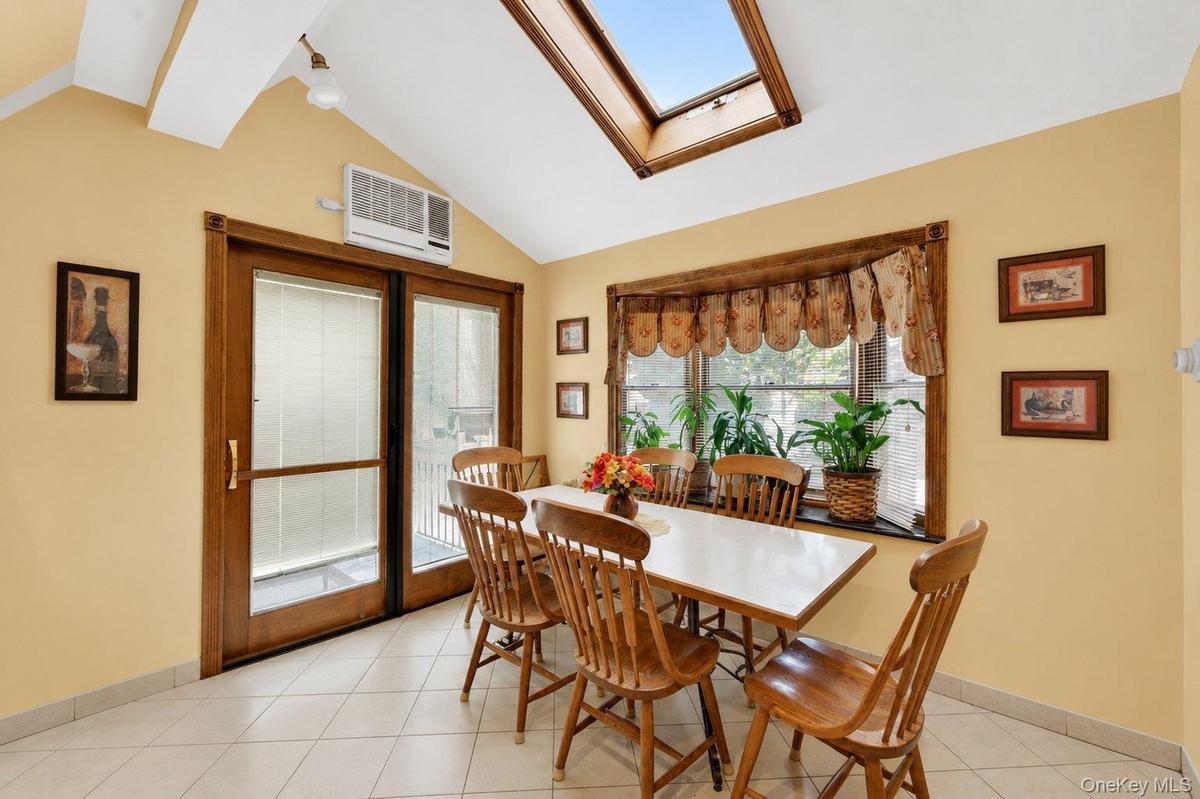 Vaulted ceiling with skylight and wood-framed window