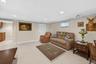 Spacious living area featuring light-toned tile flooring, recessed ceiling lighting, and neutral wall tones