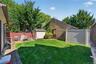 Expansive grassy yard with a paver patio and privacy fencing