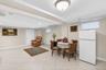Spacious lower level featuring light-toned tile flooring throughout, multiple recessed lighting fixtures, and a ceiling-mounted light fixture